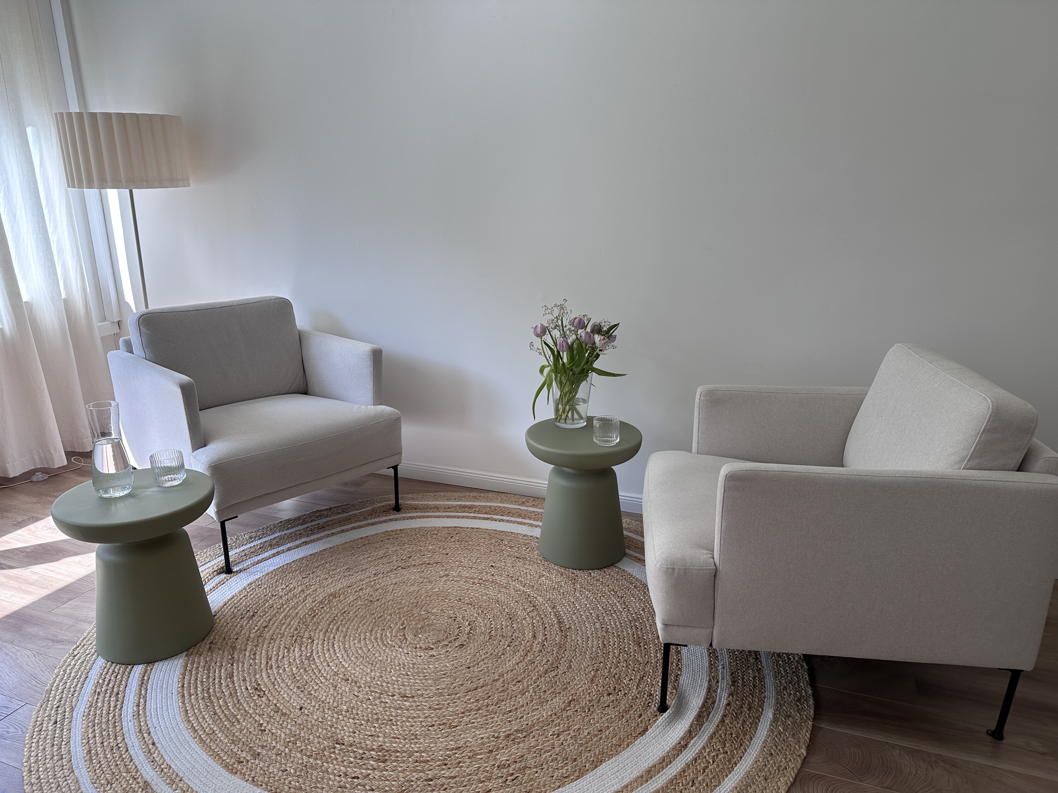 Praxisraum Hamburg-Altona mit hellen Sesseln, salbeigrünen Beistelltischen und warmer Stehlampe